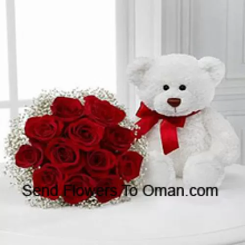 Um buquê de 12 rosas vermelhas com preenchedores sazonais junto com um fofo urso de pelúcia branco de 14 polegadas de altura