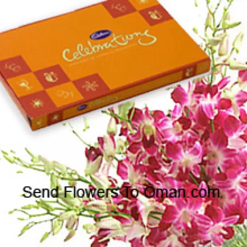 Um belo monte de orquídeas cor-de-rosa junto com uma bela caixa de chocolates Cadbury