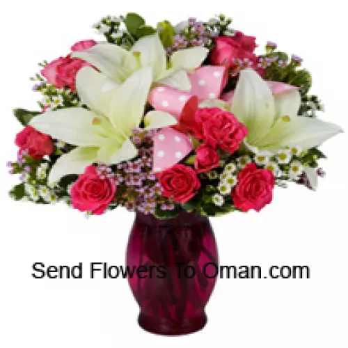 Różowe róże i białe lilie z sezonowymi dodatkami w szklanej wazie