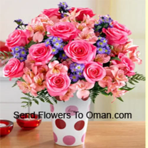 Rosa Rosen, rosa Orchideen und verschiedene lila Blumen, wunderschön arrangiert in einer Glasvase