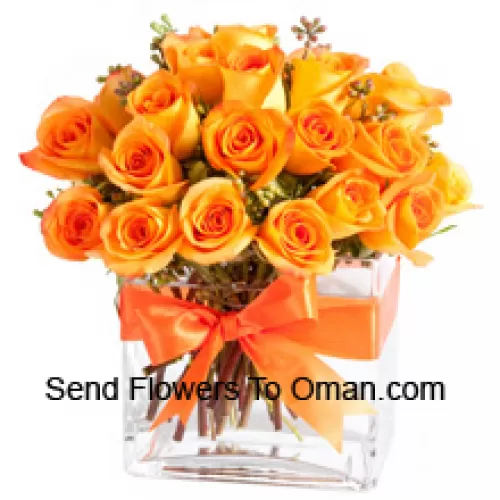 玻璃花瓶中的24朵橙色玫瑰和一些蕨类植物