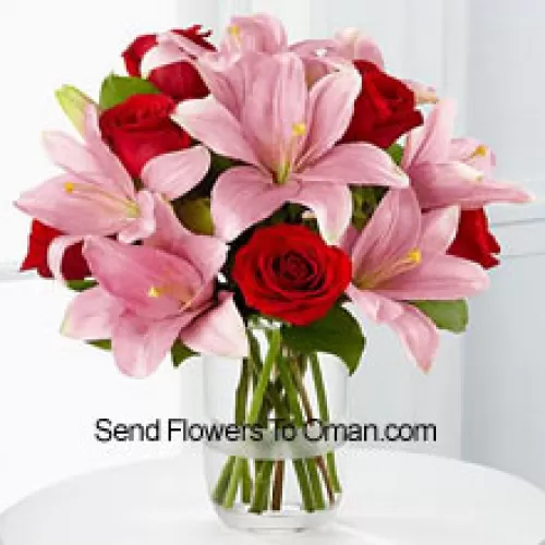 玻璃花瓶里的红玫瑰和粉色百合，搭配季节性的填充物