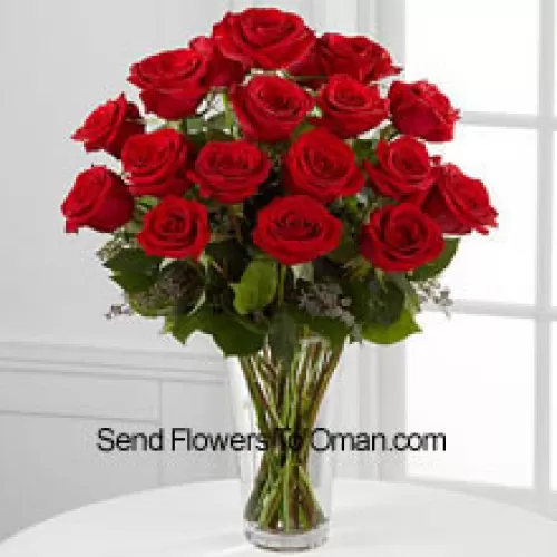 花瓶に入った18本の赤いバラとシダのアレンジメント